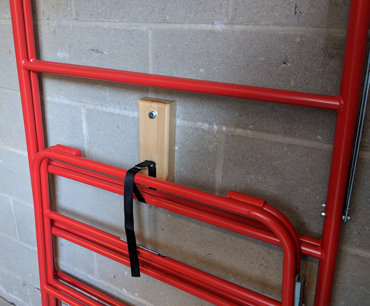 Wall fixed storage pad and strap for trestles